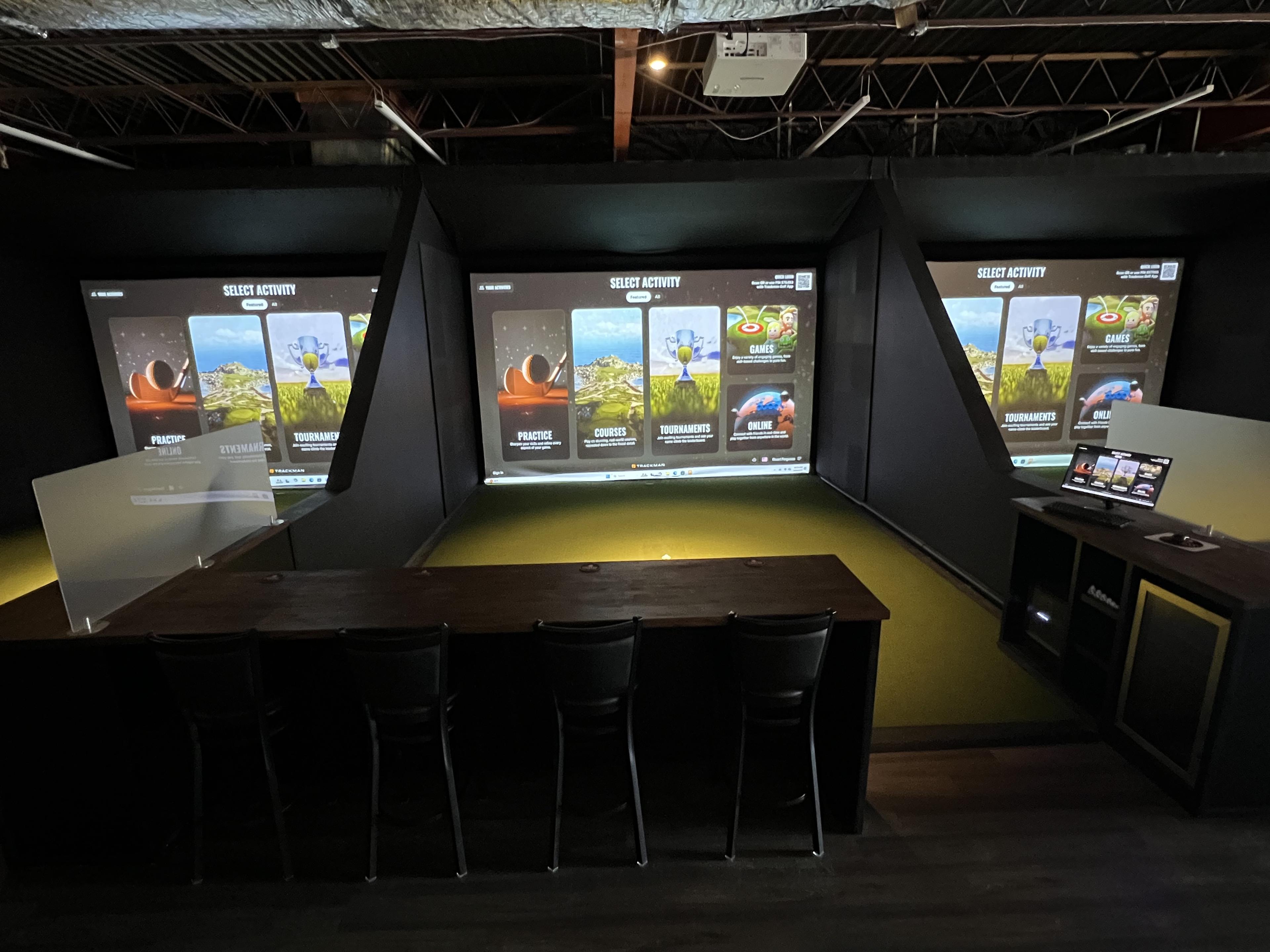 Golfers playing on indoor golf simulators at Endless 18 in Lawrenceville, New Jersey